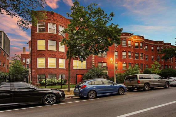Front view of a multi-story red brick building with arched windows.