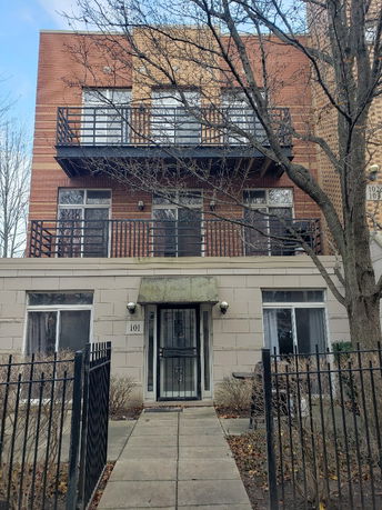 Front view of a two-story brick and concrete building with balconies.