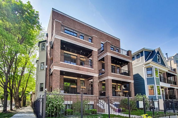 Front view of a multi-story brick building with balconies.