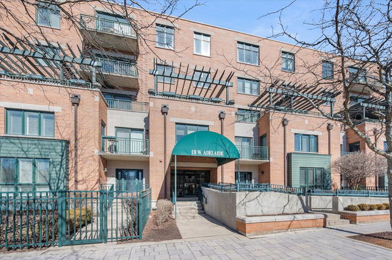 Front view of a multi-story brick apartment building with balconies.