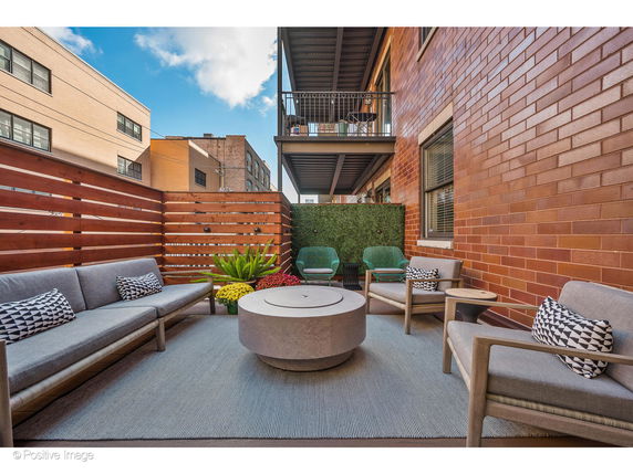 Outdoor seating area with sofas and a circular table on a balcony or terrace.