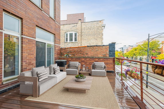 Rooftop patio with outdoor seating and a view of the street.