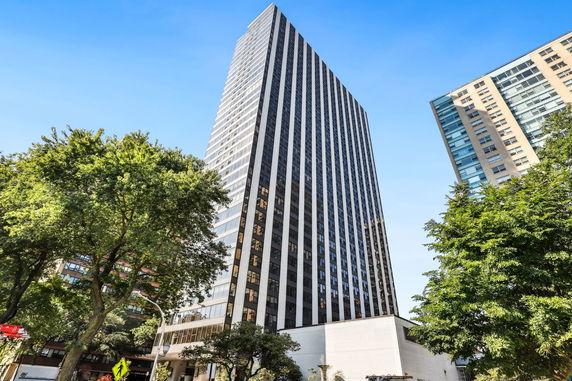 Front view of a tall skyscraper building with glass windows.
