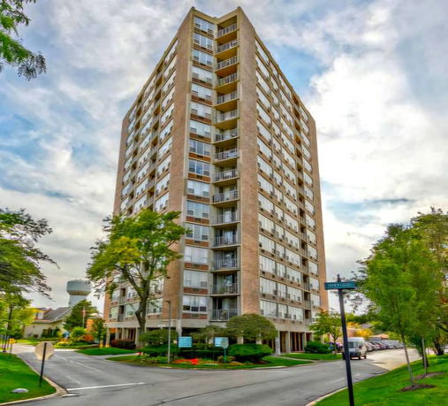 Front view of a high-rise residential building with multiple balconies.