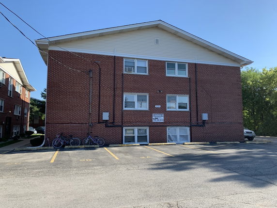 Side view of a three-story brick apartment building.