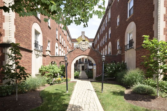 Front view of a brick building with an arched gate entrance.