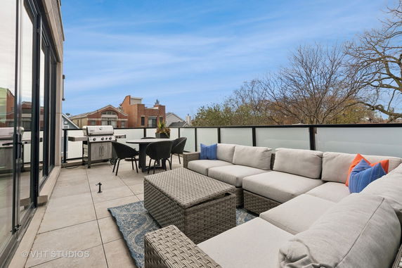 Rooftop terrace with outdoor seating and a grill.