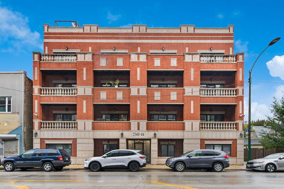 Front view of a multi-story brick building with balconies.