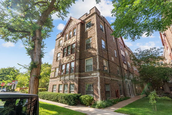 Front view of a brick apartment building with multiple floors.