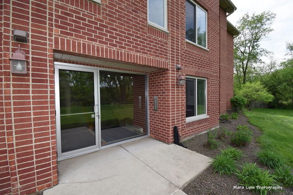 Corner view of a brick building with large windows and a sliding glass door.