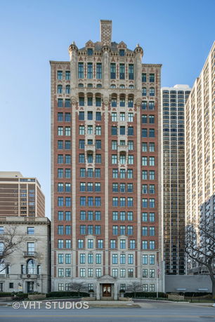 Front view of a multi-story brick building with decorative elements.
