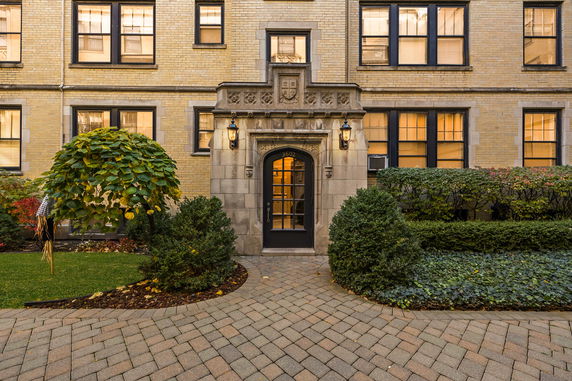 Front view of a building with decorative entrance and brick facade.