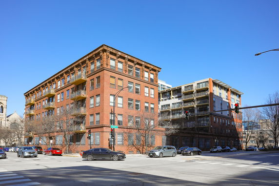 Front view of a multi-story brick building with balconies.