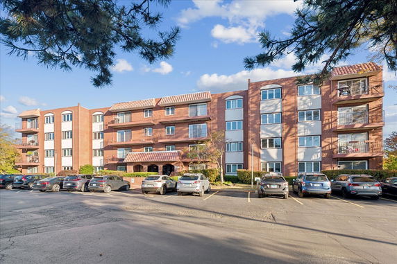 Front view of a multi-story apartment building with balconies.