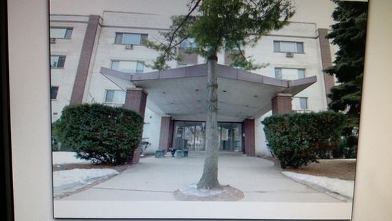 Front view of a multi-story building with an entrance canopy.