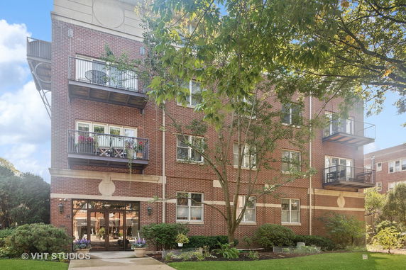 Front view of a multi-story brick apartment building with balconies.