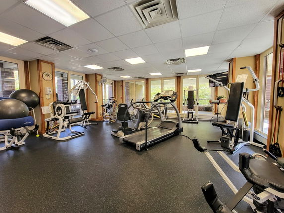 Room equipped with various fitness machines and exercise equipment.