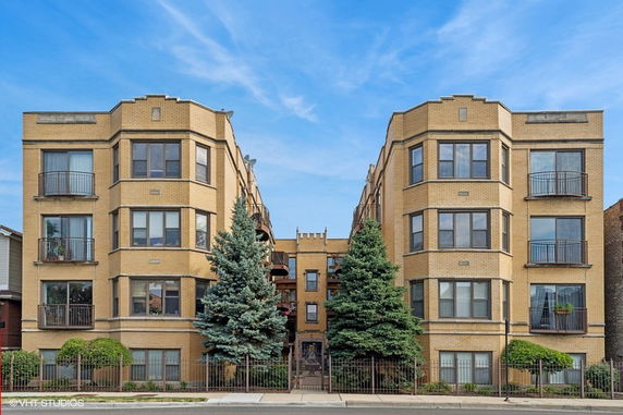 Front view of a multi-story apartment building with balconies.