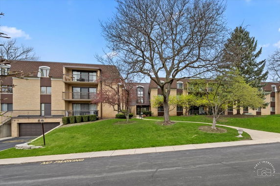 Front view of a multi-story residential building with balconies and a garage entrance.