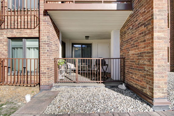 Front view of a building with a small patio enclosed by a metal railing.