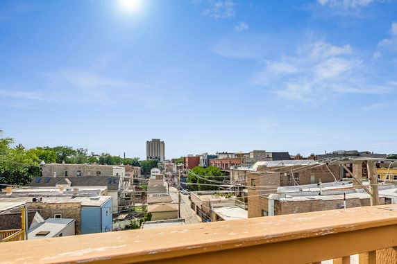 Panoramic view overlooking rooftops in a residential area with clear blue sky.
