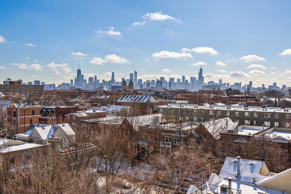 Panoramic view of a cityscape with snow-covered rooftops and prominent skyline in the background.