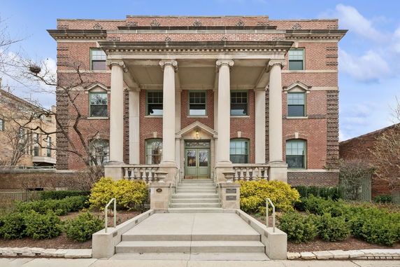 Front view of a three-story brick building with large columns and a central entrance.