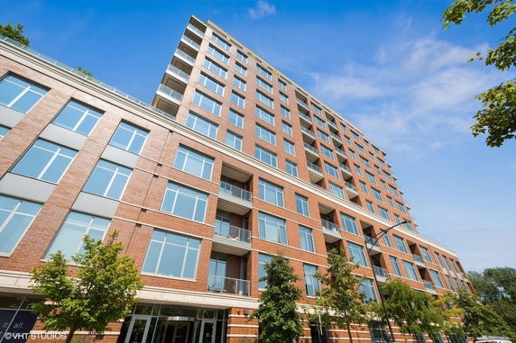 Front view of a multi-story brick building with large windows and balconies.