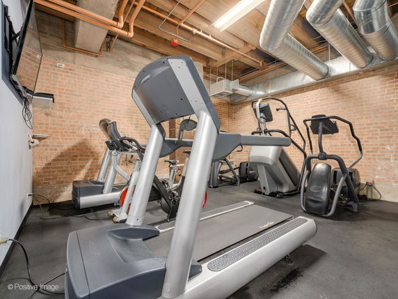 Indoor gym area with exercise equipment including a treadmill and elliptical machines.