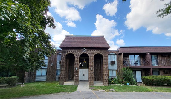 Front view of a two-story building with brick facade and arched entrance.
