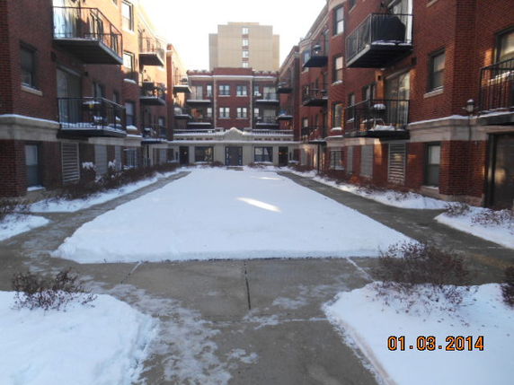 Courtyard view of brick apartment buildings with balconies.