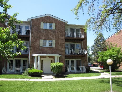Front view of a three-story apartment building with balconies.