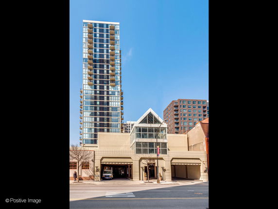 Front view of a modern high-rise building with large glass windows and multiple balconies.