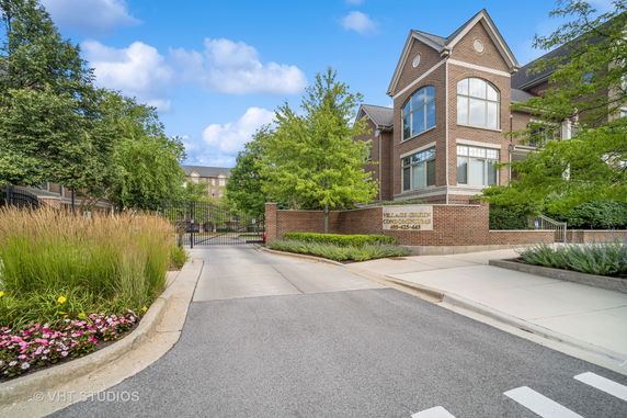 Front view of a condominium with a gated entrance and brick exterior.