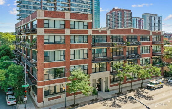 Front view of a brick apartment building with balconies.