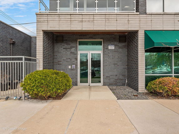 Front view of a commercial building entrance with glass doors.