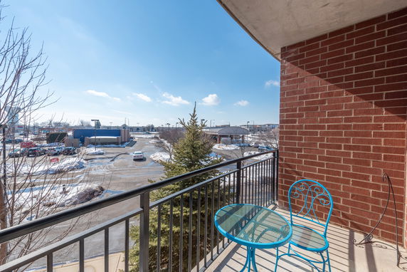 Panoramic view from a balcony showing a parking lot and surrounding area.