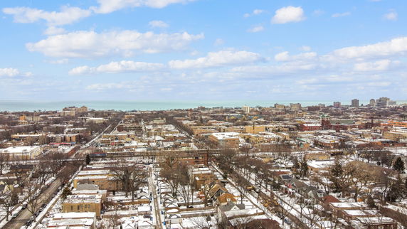 Panoramic view of a cityscape with snow-covered buildings and distant water body.