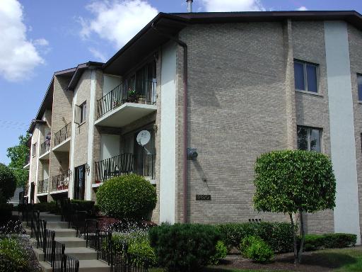 Front view of a multi-story apartment building with balconies.