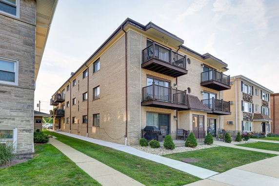 Front view of a multi-story apartment building with balconies.