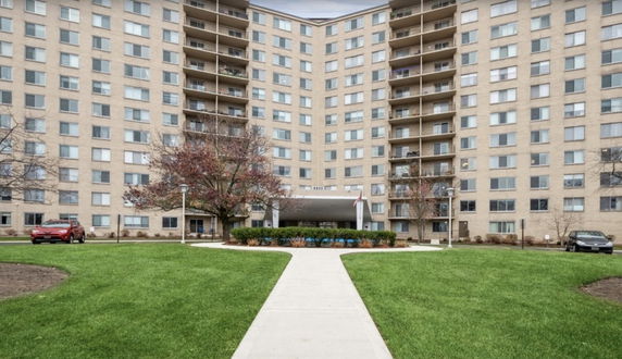 Front view of a multi-story apartment building with balconies.