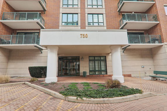 Front view of a multi-story building with balconies and entrance.