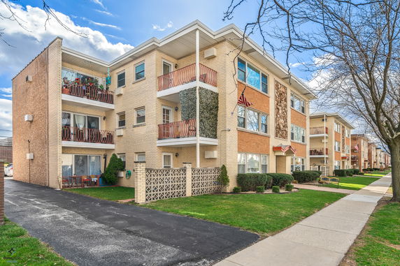 Front view of a three-story apartment building with balconies.