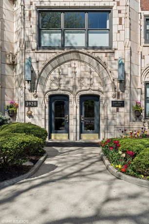 Front view of an ornate building entrance with decorative stonework and double doors.