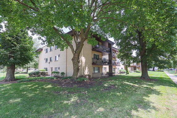 Front view of a three-story apartment building with balconies.