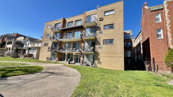 Front view of a multi-story apartment building with balconies.