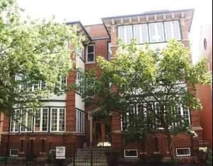 Front view of a multi-story brick building with large windows.