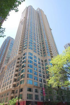 Front view of a tall residential building with multiple balconies.