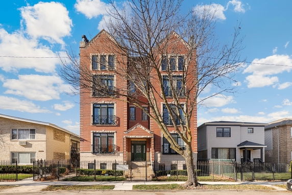 Front view of a multi-story brick building with a symmetrical facade.