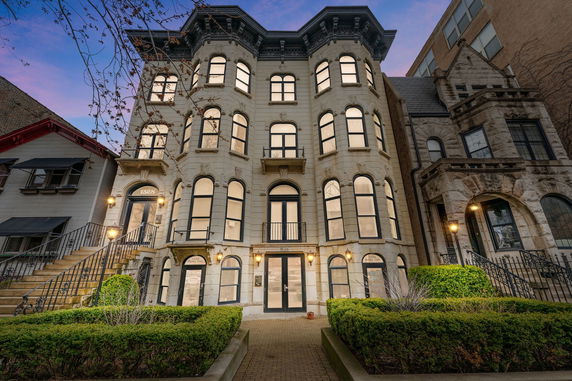 Front view of a multi-story historic building with ornate windows and decorative architecture.